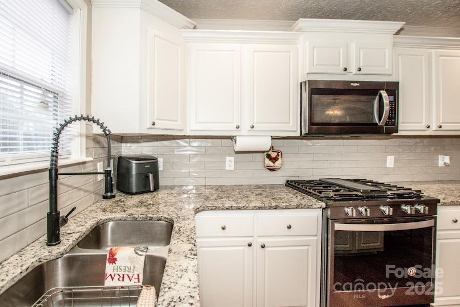 224 Stewart Rock Road Stony Point, NC 28678 - Photo 17 of 41 a kitchen with granite countertop a stove sink and microwave