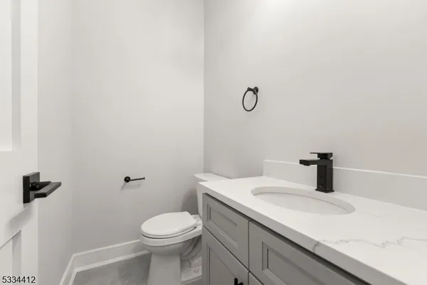 a view of kitchen with kitchen island a sink wooden floor and white cabinets