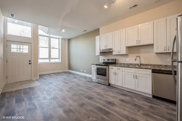 a kitchen with granite countertop white cabinets and white appliances