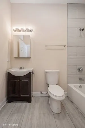 a bathroom with a sink vanity mirror and toilet