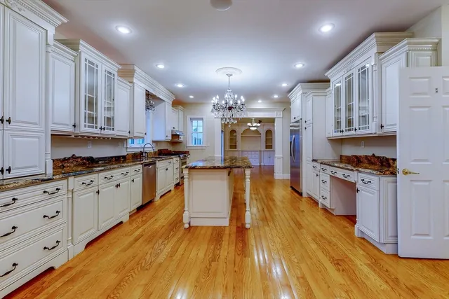 a large kitchen with cabinets wooden floor and stainless steel appliances