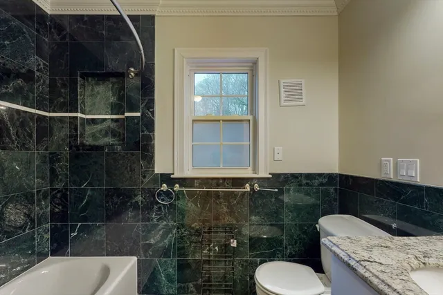 a bathroom with a toilet a sink and mirror
