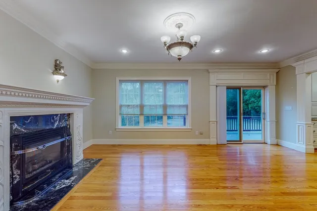 an empty room with wooden floor and fireplace