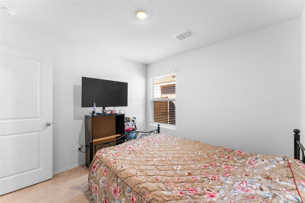 241 Thresher Lane Princeton, TX 75407 - Photo 16 of 33 a bedroom with a bed and a flat screen tv