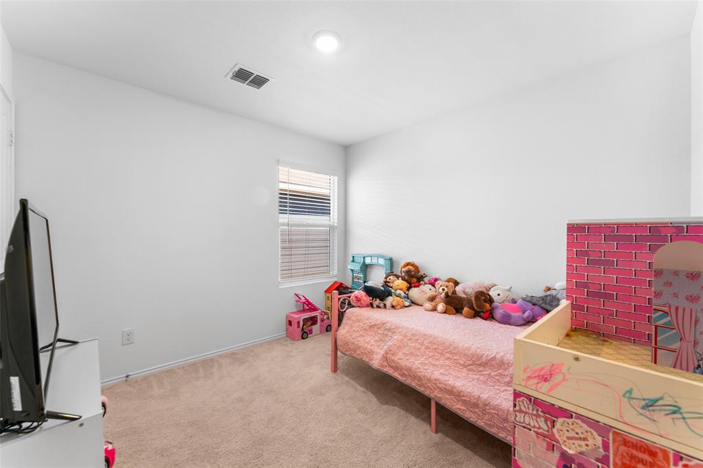 241 Thresher Lane Princeton, TX 75407 - Photo 19 of 33 a bedroom with a bed and a couch