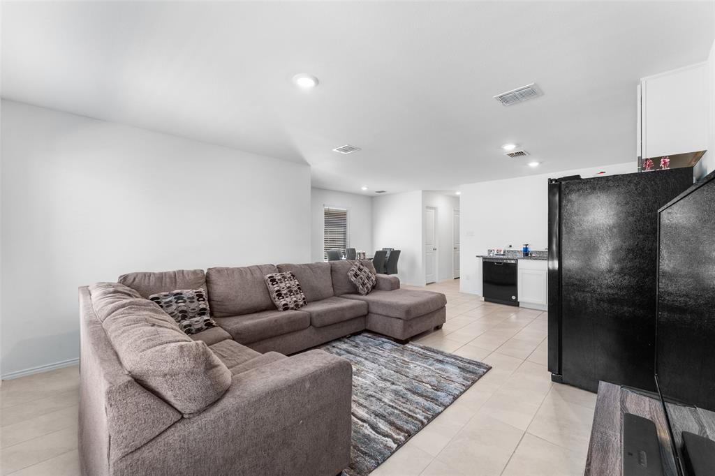 241 Thresher Lane Princeton, TX 75407 - Photo 5 of 33 a living room with furniture and a refrigerator