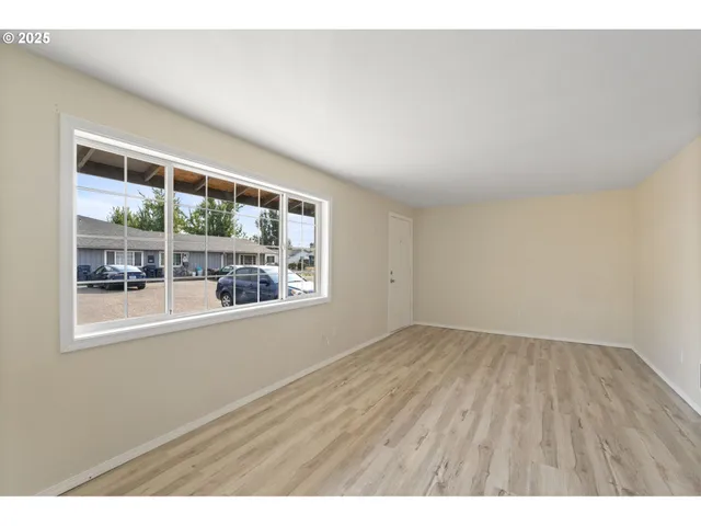 a view of a room with wooden floor and a window