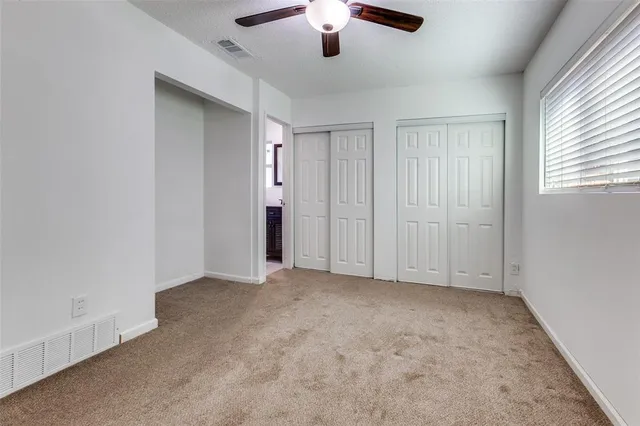 an empty room with chandelier fan