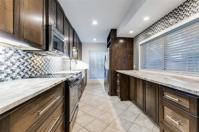 a kitchen with granite countertop stainless steel appliances and wooden cabinets