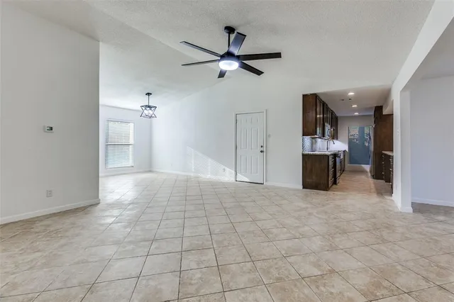 a view of empty room with a ceiling fan and window