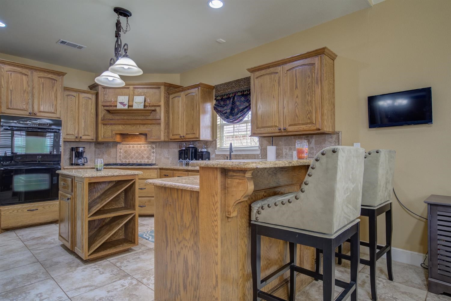 5904 110th Street Lubbock, TX 79424 - Photo 14 of 50 a kitchen with a table chairs microwave and cabinets