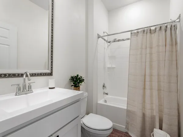 a bathroom with a sink a toilet a mirror and shower
