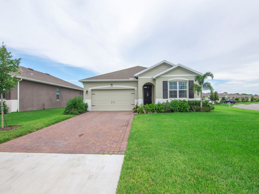 2040 Amazon Way Southwest Vero Beach, FL 32962 - Photo 27 of 35 a front view of a house with a yard and garage
