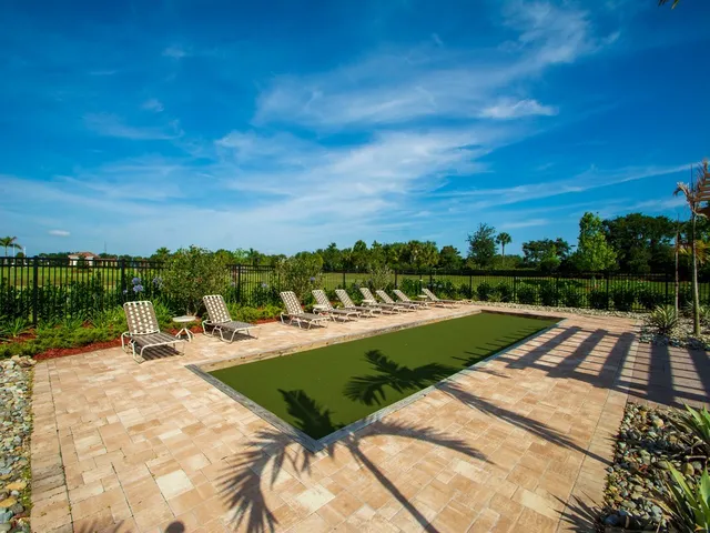 a view of a swimming pool with a lounge chair and palm trees