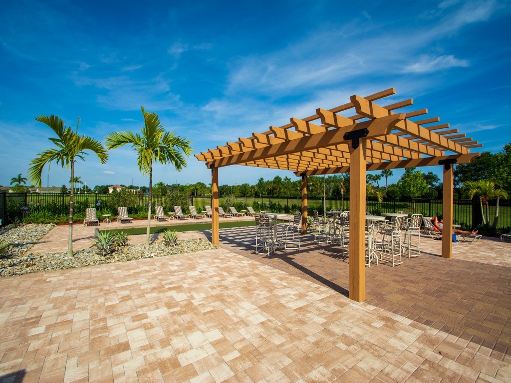 2040 Amazon Way Southwest Vero Beach, FL 32962 - Photo 32 of 35 a view of a swimming pool with a lounge chair and palm trees