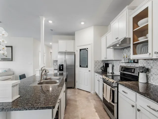 a kitchen with stainless steel appliances granite countertop a sink stove and refrigerator