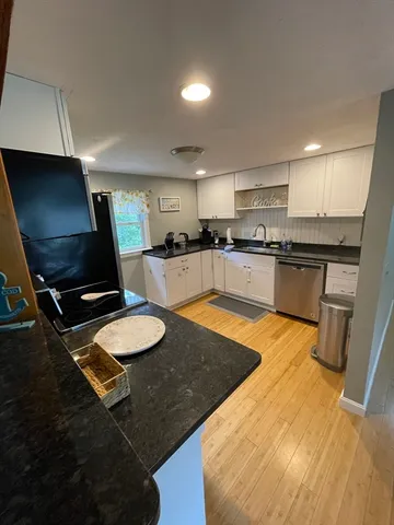 a kitchen with granite countertop a sink appliances and cabinets