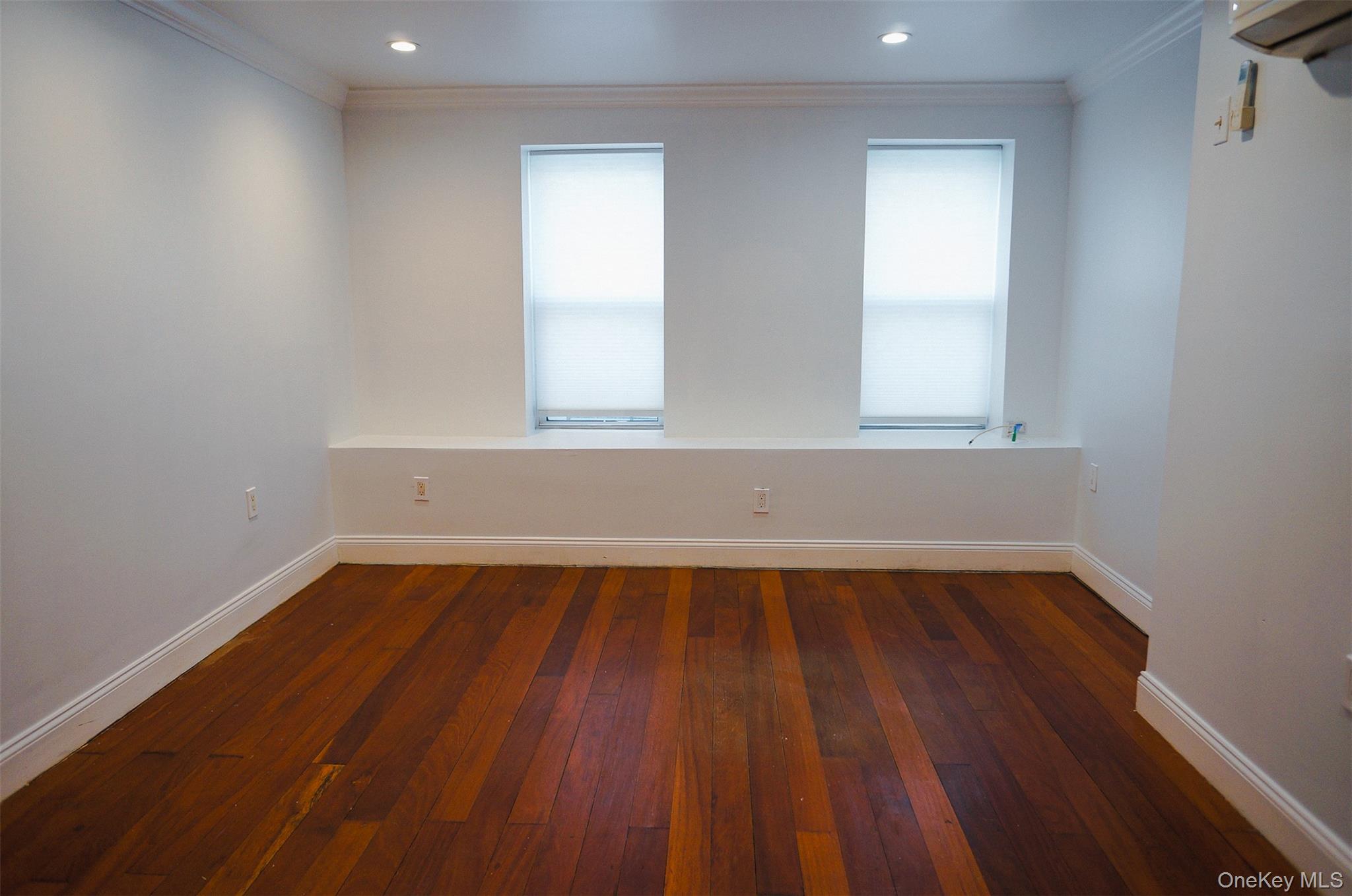 526 East 148th Street, Unit 1 Bronx, NY 10455 - Photo 6 of 13 an empty room with wooden floor and windows