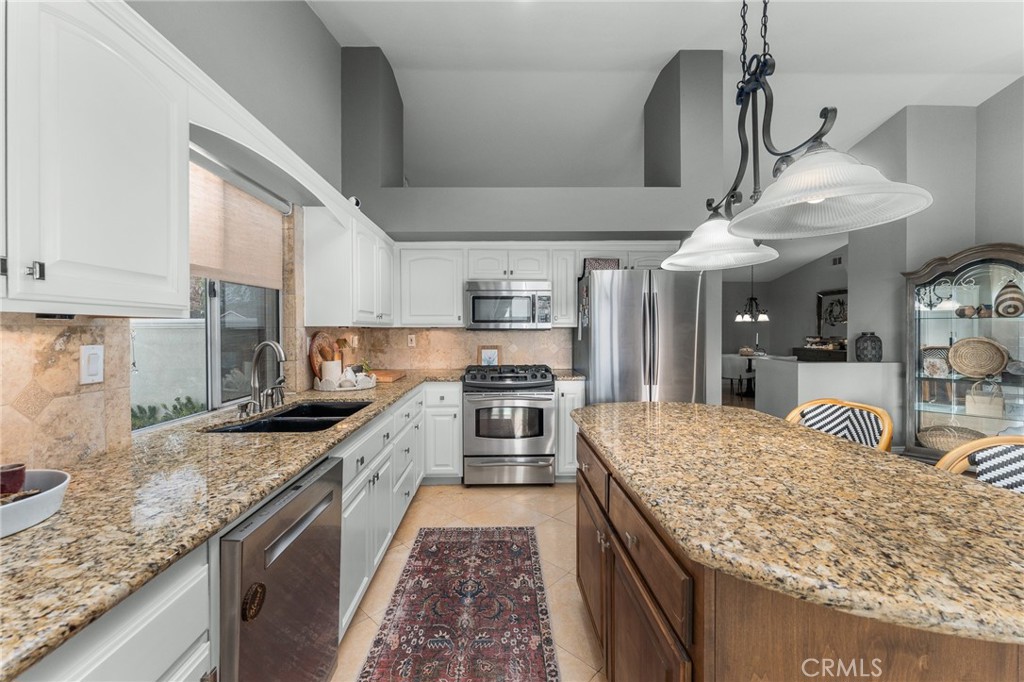 4021 North Larkspur Avenue Rialto, CA 92377 - Photo 12 of 40 a kitchen with stainless steel appliances granite countertop a sink stove and refrigerator