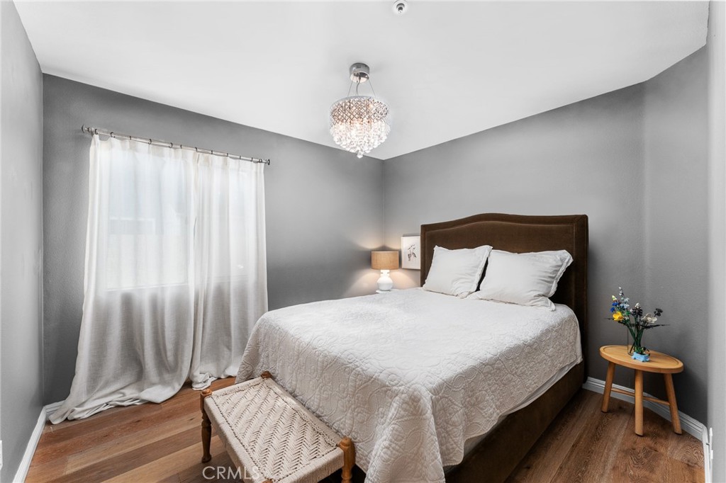 4021 North Larkspur Avenue Rialto, CA 92377 - Photo 20 of 40 a bedroom with a bed and a chandelier