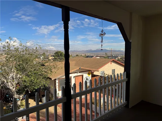 a view of a balcony with a floor to ceiling window next to a yard