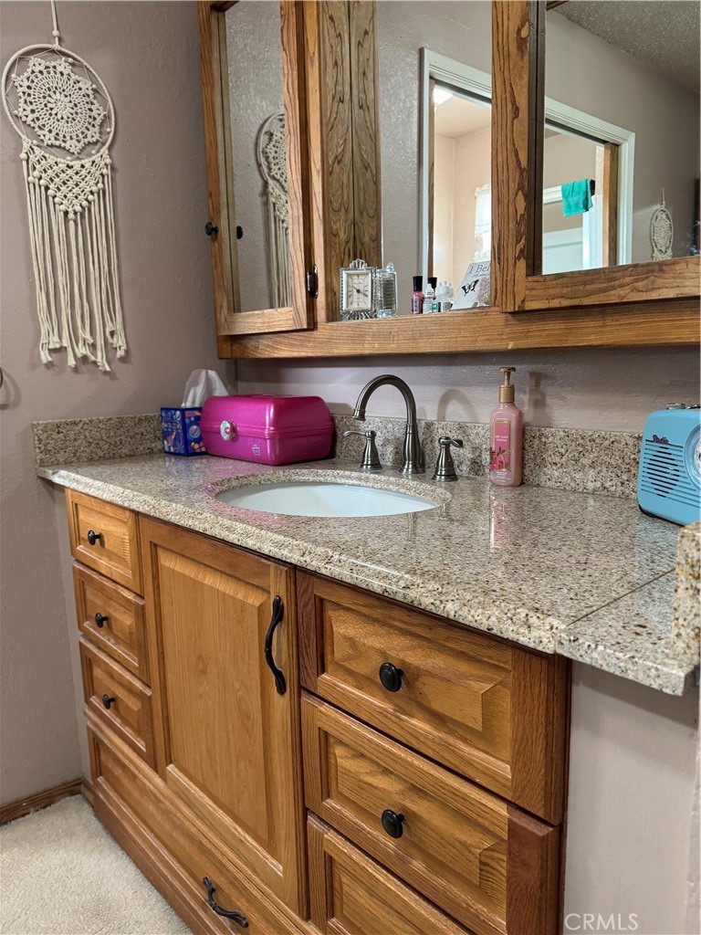 751 Rimrock Road Barstow, CA 92311 - Photo 20 of 33 a bathroom with a granite countertop sink and a mirror