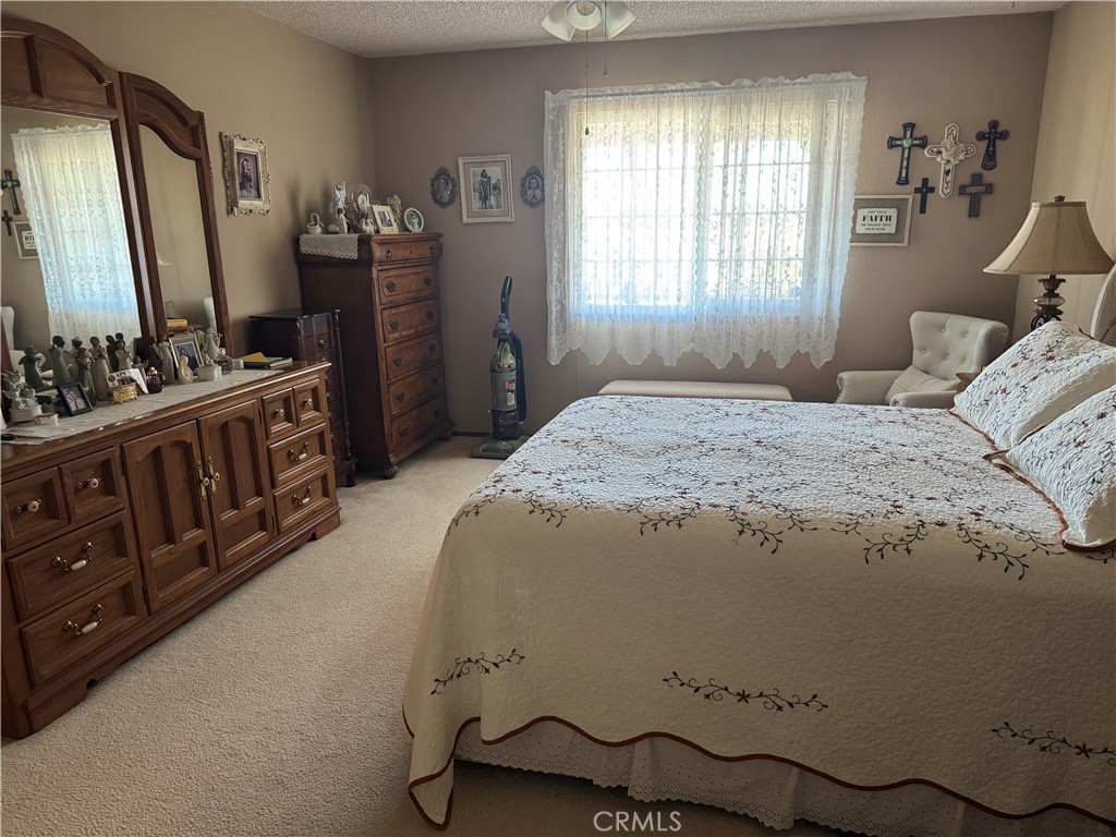 751 Rimrock Road Barstow, CA 92311 - Photo 21 of 33 a bedroom with a bed and dresser with mirror