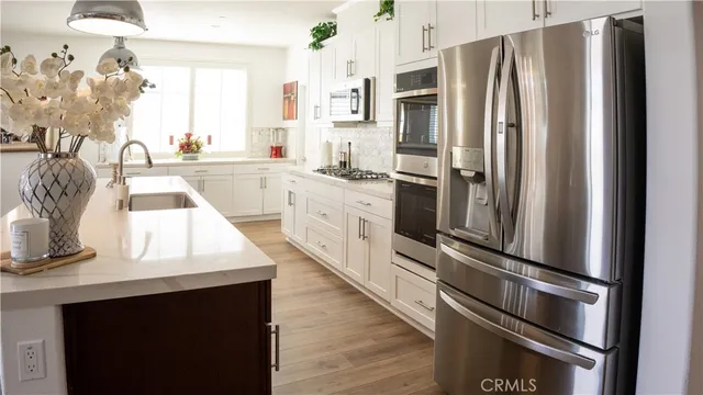 a kitchen with white cabinets and stainless steel appliances