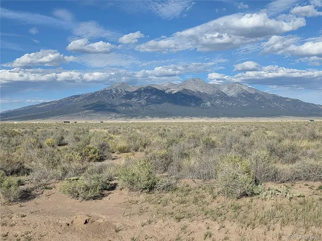 a view of yard with mountain and trees in the background