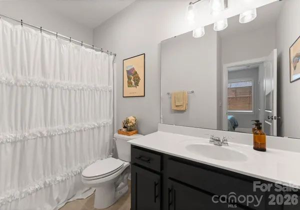 a spacious bedroom with a bed and a chandelier