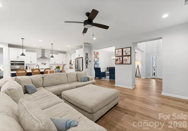 a kitchen with stainless steel appliances kitchen island granite countertop a table chairs sink and cabinets