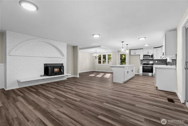 a view of kitchen with microwave stove refrigerator and oven