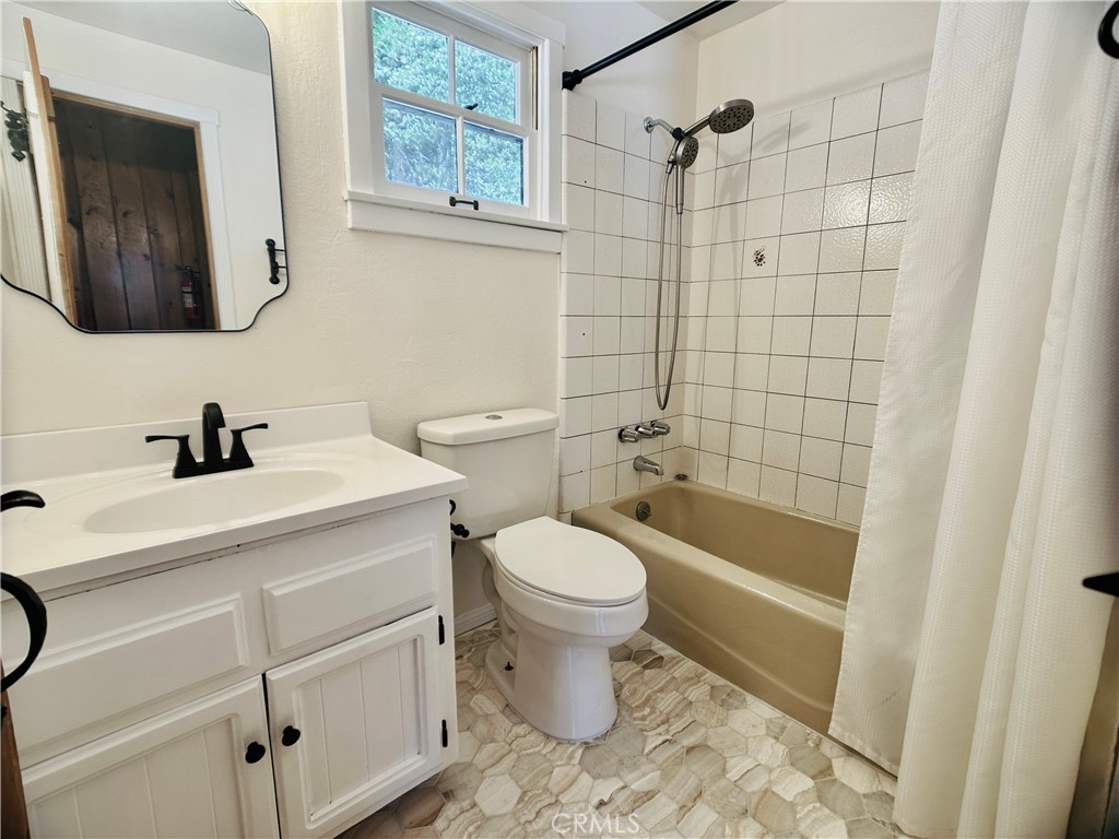 349 Golf Course Road Lake Arrowhead, CA 92352 - Photo 25 of 58 a bathroom with a toilet sink and mirror