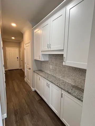 a kitchen with granite countertop a sink and cabinets