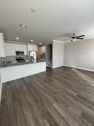 a view of a kitchen with a sink and wooden floor