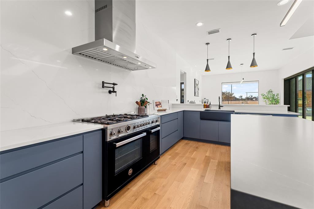 5020 Montgomery Road Midlothian, TX 76065 - Photo 13 of 40 Kitchen featuring exhaust hood, light wood-style flooring, double oven range, modern cabinets, and hanging light fixtures