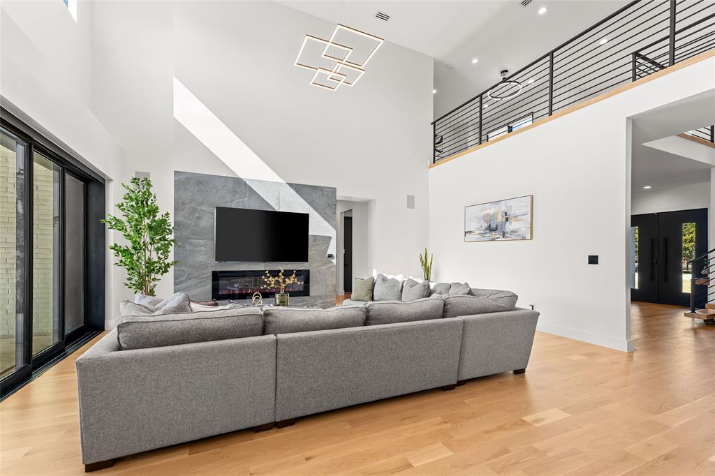5020 Montgomery Road Midlothian, TX 76065 - Photo 17 of 40 Living room with light wood-style floors, a high end fireplace, and a high ceiling