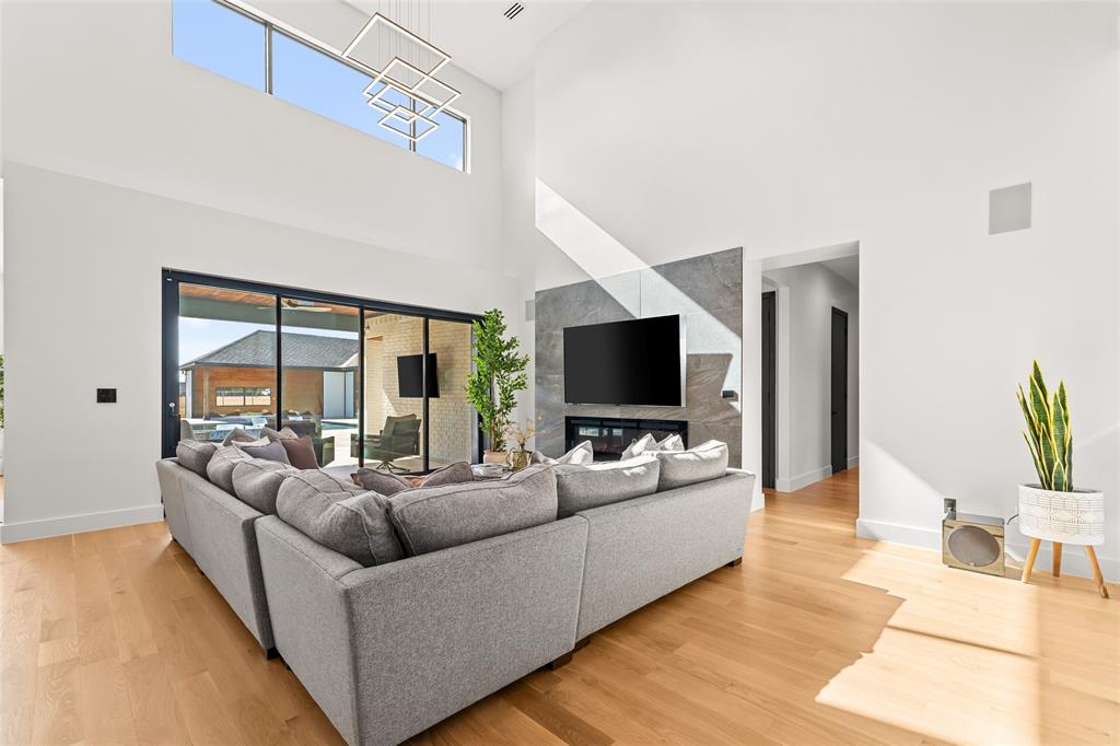 5020 Montgomery Road Midlothian, TX 76065 - Photo 19 of 40 Living room with light wood-style flooring, a fireplace, and a high ceiling
