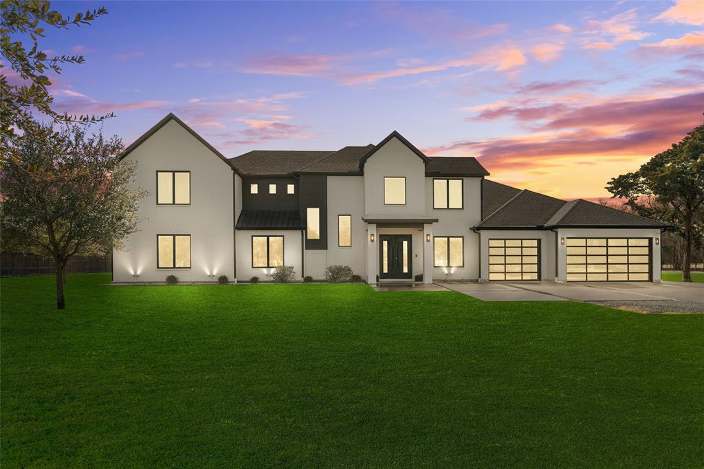 5020 Montgomery Road Midlothian, TX 76065 - Photo 36 of 40 View of front facade featuring a front yard, a garage, driveway, stucco siding, and a standing seam roof