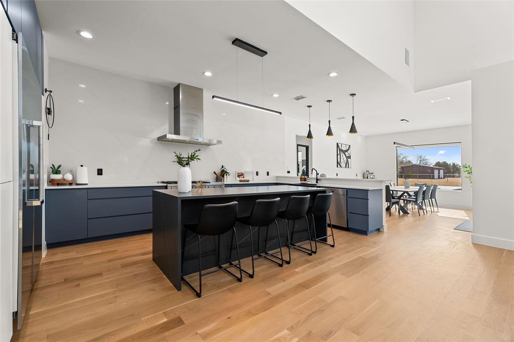 5020 Montgomery Road Midlothian, TX 76065 - Photo 9 of 40 Kitchen featuring a kitchen breakfast bar, decorative light fixtures, modern cabinets, light wood-style floors, and a center island