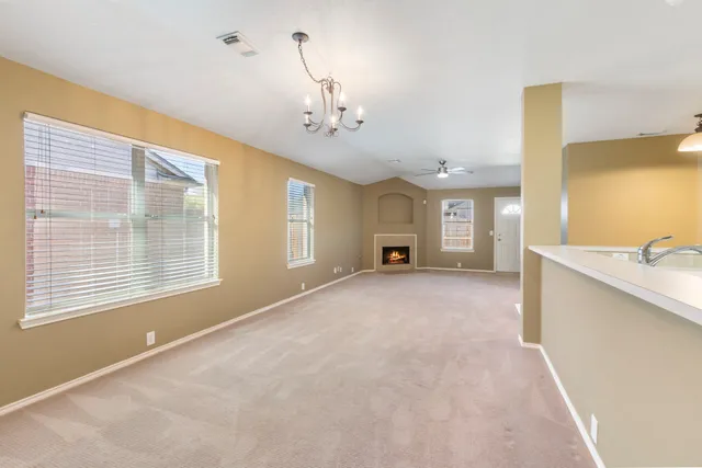 an empty room with windows and fireplace