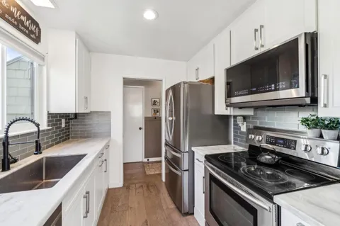 a kitchen with stainless steel appliances a stove microwave and sink