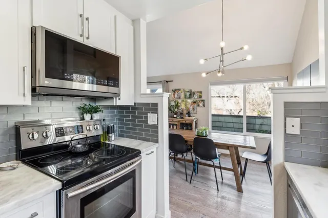 a kitchen with stainless steel appliances kitchen island granite countertop a stove a sink and a microwave