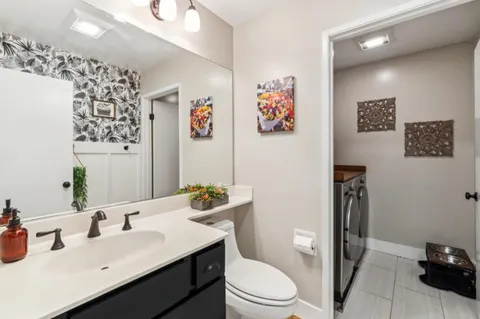 a bathroom with a sink mirror vanity and toilet