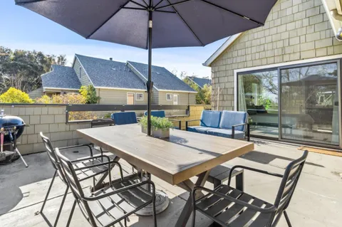 a view of a patio with a table and chairs under an umbrella