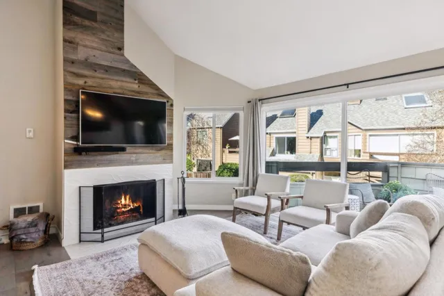 a living room with furniture a fireplace and a flat screen tv