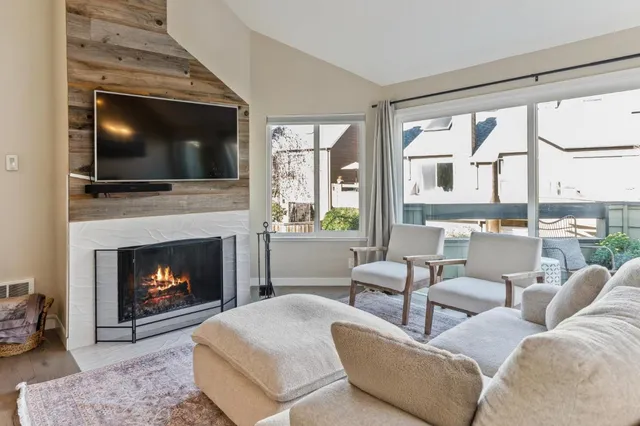 a living room with furniture a flat screen tv and a fireplace