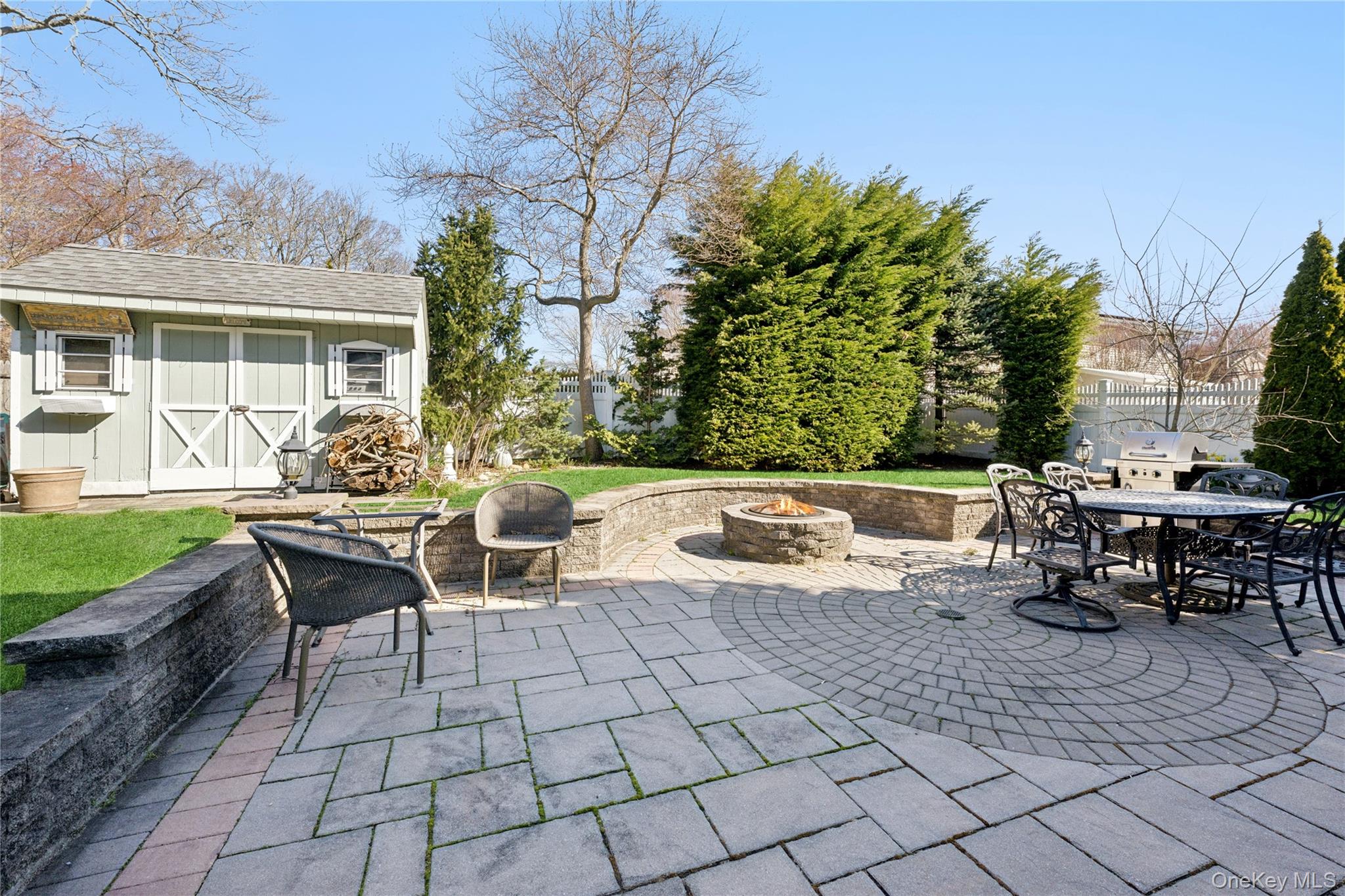 44 Archie Place West Islip, NY 11795 - Photo 28 of 36 a view of a patio with dining table and chairs with a fire pit