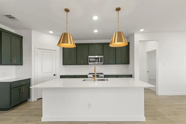 a kitchen with stainless steel appliances a sink stove and refrigerator