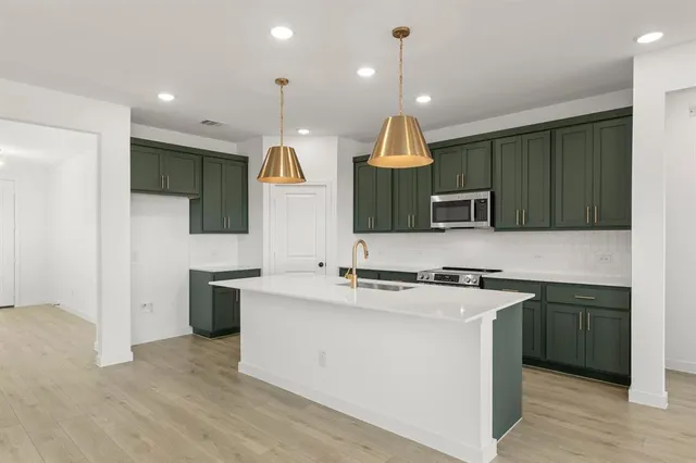 a kitchen with stainless steel appliances granite countertop a sink and a stove